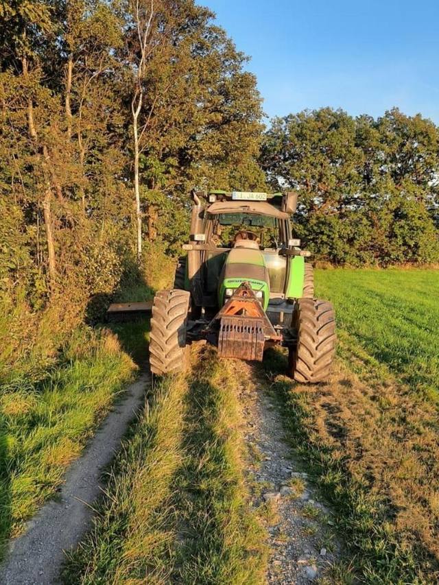 Schlepper mit Seitenmulcher bei der Wegrandpflege am Feldweg